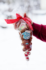 Christmas gift with gingerbreads on snow background.