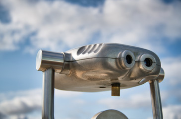 Binocular with city view and sky on the background