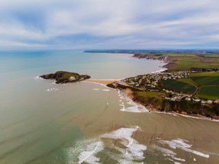bigbury island on the south devon coast from a drone with surfers