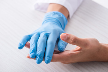 cropped view of doctor with latex glove on hand