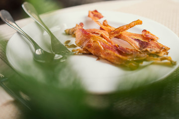 crispy fried bacon on white dish with selective focus point