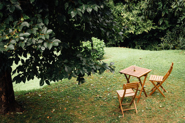 une table et des chaises en bois dans un jardin
