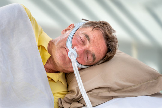 Man wearinhg a maslk Sleep Apnea and CPAP. Prescription, to sleep for safe life