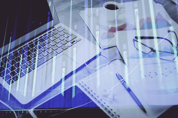 Stock market graph on background with desk and personal computer. Double exposure. Concept of financial analysis.