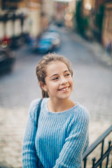 Little girl in an urban setting smiles at the camera.