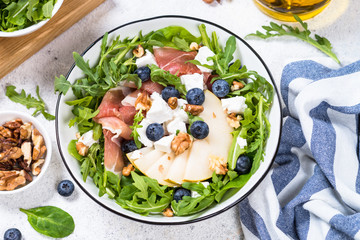 Green salad with leaves, fruit and jamon.