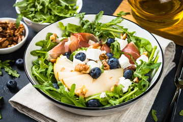 Green salad with leaves, fruit and jamon.