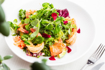 Healthy Salad. Recipe for fresh seafood. Grilled shrimps, prawns, fresh salad lettuce and avocado slices. Healthy Eating. White background. Horizontal photo.