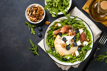 Green salad with leaves, fruit and jamon.