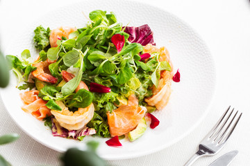 Healthy Salad. Recipe for fresh seafood. Grilled shrimps, prawns, fresh salad lettuce and avocado slices. Healthy Eating. White background. Horizontal photo.