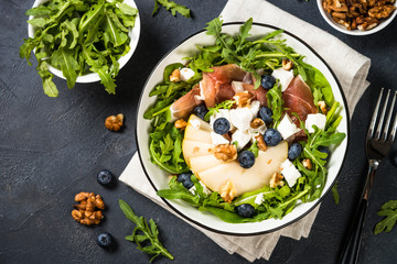 Green salad with leaves, fruit and jamon.