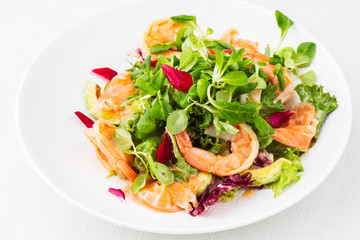 Healthy Salad. Recipe for fresh seafood. Grilled shrimps, prawns, fresh salad lettuce and avocado slices. Healthy Eating. White background. Horizontal photo.