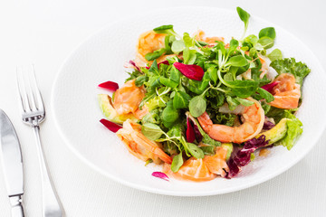 Healthy Salad. Recipe for fresh seafood. Grilled shrimps, prawns, fresh salad lettuce and avocado slices. Healthy Eating. White background. Horizontal photo.