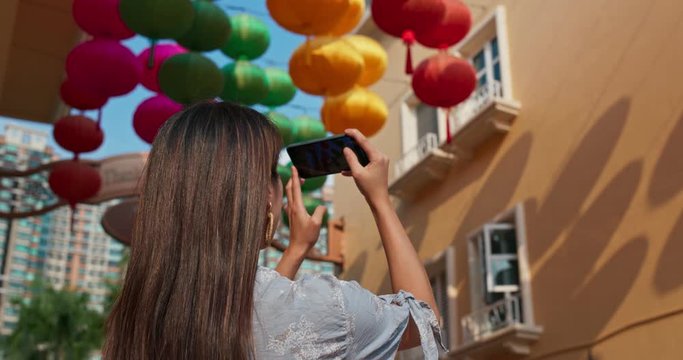 Woman take photo on cellphone with Chinese lantern