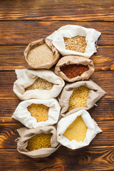 Textile bags full of organic bio cereals, flat lay. Healthy eating concept