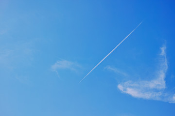 ほぼ快晴の青空と斜めに浮かぶ飛行機雲