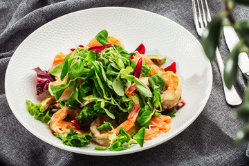 Healthy Salad. Recipe for fresh seafood. Grilled shrimps, prawns, fresh salad lettuce and avocado slices. Healthy Eating. White background. Horizontal photo.