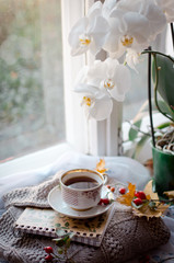 cup of coffee and flowers on wooden table