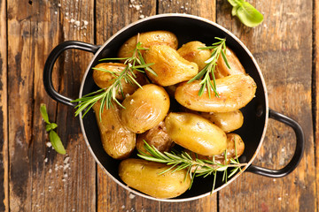 roasted potato and rosemary on wood background