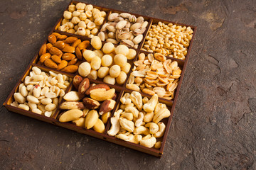 Set of various nuts in wooden box over grunge background