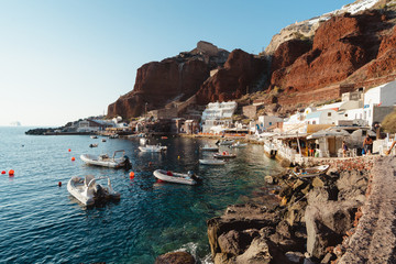 The small coastal fishing village of Amoudi Bay, in Santorini, Greece. Beautiful tiny village at...