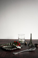 Flat lay still life of vintage antique decorative items with plant, berry, candle, and silver plate. Dark wooden background for festive christmas use with copy space.