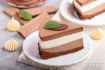 Cake with souffle milk chocolate cream with cup of coffee on a gray concrete background. side view, selective focus.