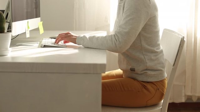 Backache of a woman. A female suffers from a sore back while sitting at a desk.