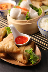 asian food with samosa, dumpling, spring roll and sauce