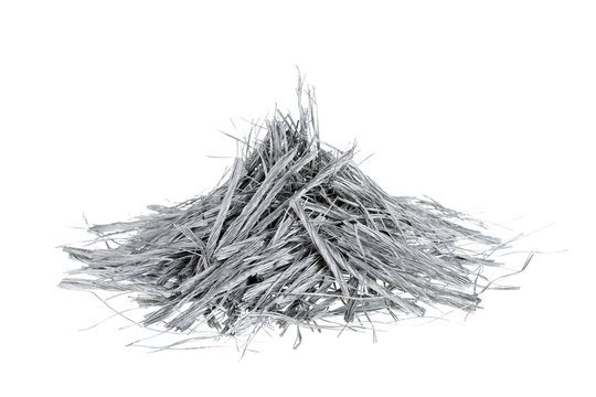 Heap of bundles of grey colored polypropylene fiber for concrete structural reinforcement, isolated on white background