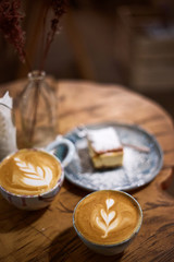Cup of cappuccino coffee with cake on a rustic wooden table