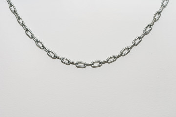 Iron chain hanging on a white background wall