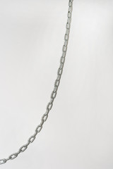 Iron chain hanging on a white background wall