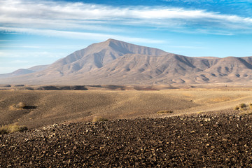 Sand, rock and lava formation with mountain in the background on Lanzarote, Canary islands, Spain
