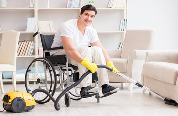 Disabled man with vacuum cleaner at home