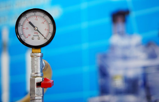 View of analog meter ,steel pipes and industrial process equipment background             