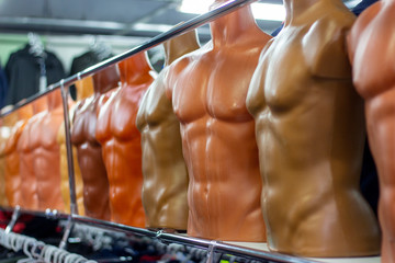 Many different plastic naked male mannequins in the clothing shop