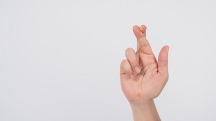 Naklejka premium Male's right hand doing Crossed fingers sign on white background.
