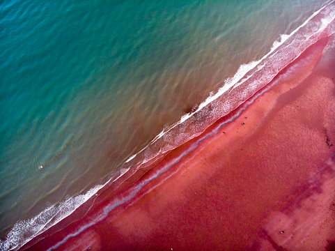 devon beach in paignton with blue water and red beach