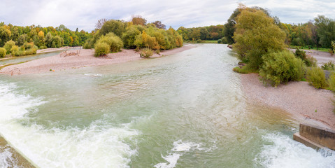 Auenlandschaft an der Isar, Fluss durch München im Herbst. Blick von der Flaucherbrücke