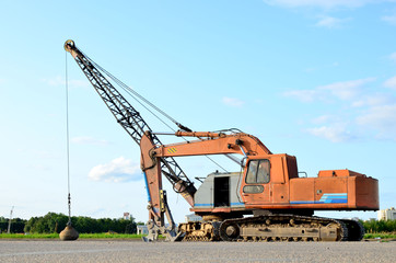 Excavator with hydraulic shears breaks asphalt on a construction site. Hydraulic shear crusher pulverizer for excavator. Heavy-duty mechanical concrete crusher. Attachments Equipment - Image