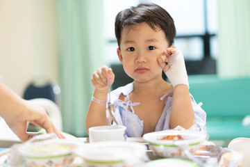 A patient boy is bored with food while he sick in the hospital.