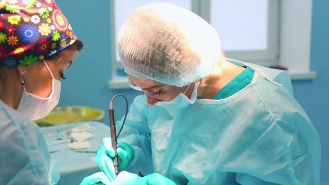 A team of surgeons has a major plan during surgery, a blue light operating room, a rhinoplasty operation to improve the aesthetics of the nose. Medetsina, plastic surgery.