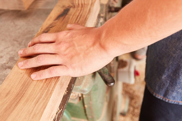 Hand von einem Tischler auf einem Balken