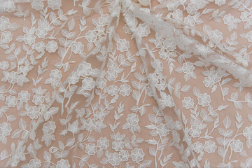 Texture lace fabric. lace on white background studio. thin fabric made of yarn or thread. a background image of ivory-colored lace cloth. White lace on beige background.
