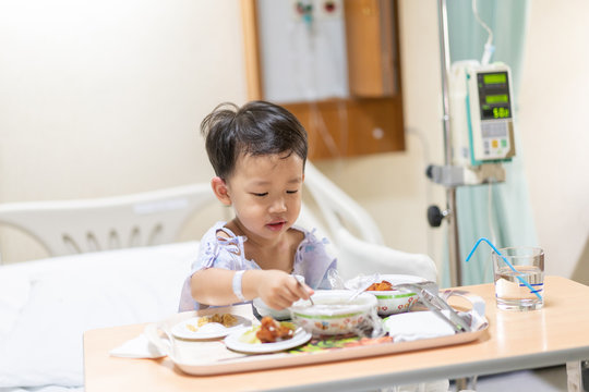 A patient boy is eatting food while he sick in the hospital.