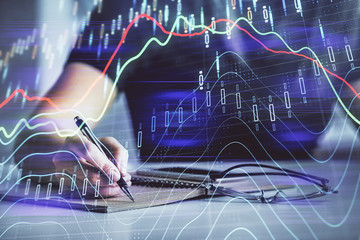Multi exposure of woman's hands making notes with forex graph hologram. Concept of technical analysis.