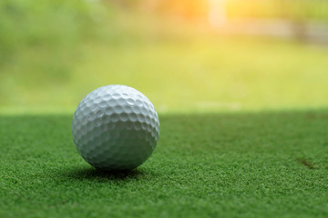 Golf ball on green grass in the evening golf course