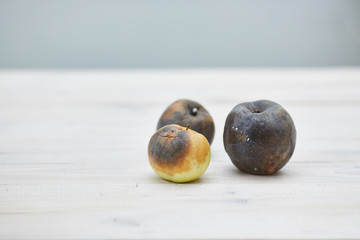 ugly fruit. three rotten apples on the table