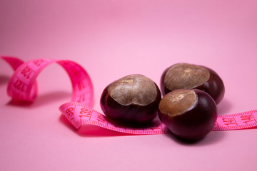 A centimeter tape and chestnuts near it. Fitness concept.